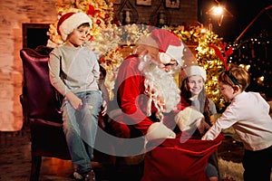 Santa Claus gives presents to children on Christmas Day.