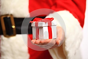 Santa Claus gloved hands holding gift box