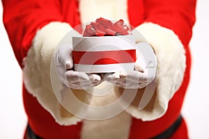 Santa Claus gloved hands holding gift box