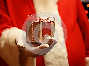 Santa Claus gloved hands holding giftbox