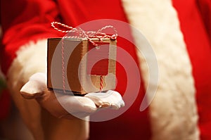 Santa Claus gloved hands holding giftbox