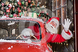 Santa claus greeting while driving a red retro car. Merry Christmas