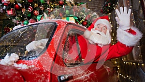 Santa claus greeting while driving a red retro car. Merry Christmas