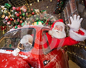 Santa claus greeting while driving a red retro car. Merry Christmas