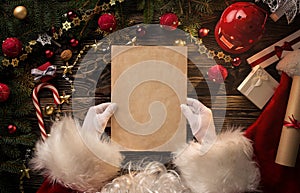 Santa Claus hands holding blank letter