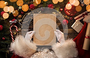 Santa Claus hands holding blank letter