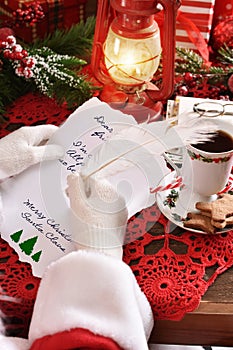 Santa Claus handwriting a letter with a quill pen