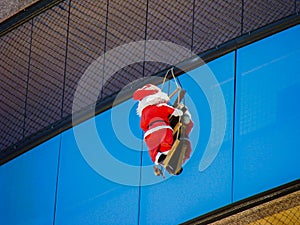 Santa Claus is hanging on the glass surface of the house