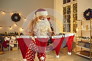 Santa Claus hanging his hats to dry on clothes line after doing laundry on winter holidays