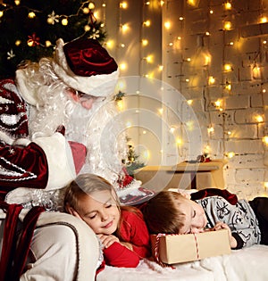 Santa Claus with happy little cute children boy and girl near Christmas tree