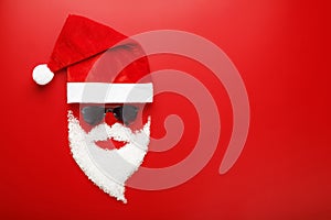 Santa Claus Hat and beard made of snow with black glasses on red background