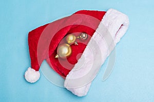 Santa Claus hat and christmas balls on blue background