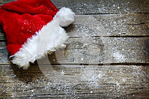 Santa Claus hat on vintage wooden boards christmas background