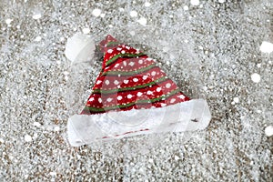 The Santa Claus hat on a wooden background in the snow