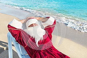 Santa Claus have a rest in lounge on sea beach