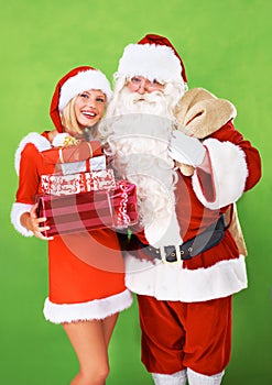 Santa claus, helper and Christmas present in studio for festive season, holiday vacation or giving. Woman, old man and