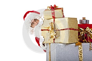 Santa Claus hiding behind christmas gift boxes