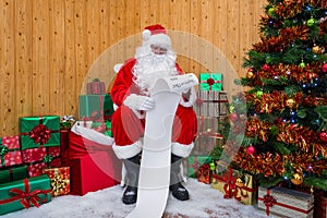 Santa Claus in a grotto checking the naughty or nice list