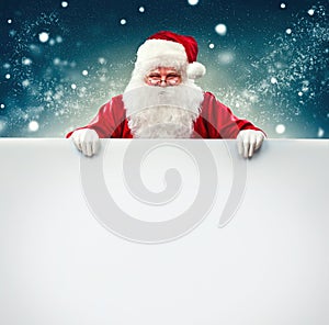 Santa Claus holding blank advertisement banner