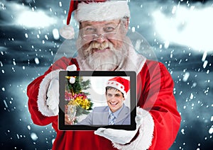 Santa claus holding a digital tablet with photo of man