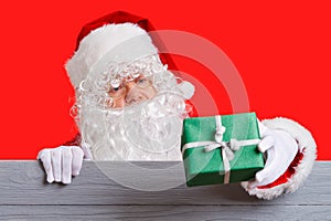 Santa Claus holding green giftbox in him hand. Christmas sale concept