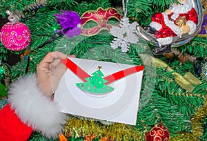 Santa Claus is holding a letter at the North Pole in Lapland - against the background of Christmas trees