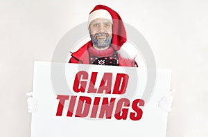 Santa Claus is holding a sign with the inscription - GLAD TIDINGS