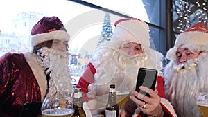 Santa Claus holding a smart phone with a Christmas massage, using a mobile application