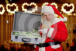Santa Claus holding suitcase with money.