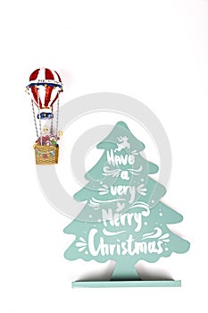 Santa Claus in Hot air balloon flight up to a wood green tree, on white background