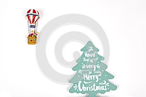 Santa Claus in Hot air balloon flight up to a wood green tree, on white background