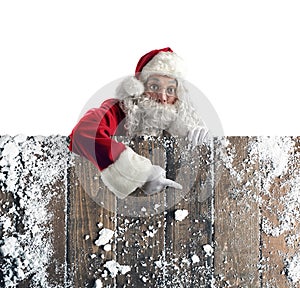 Santa claus indicate something with hand in a wooden wall