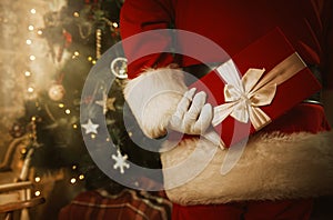 Santa Claus inside a home,holding a christmas present