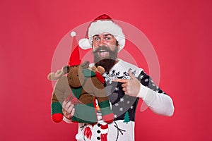 Santa Claus Ive been good. Santa point finger at reindeer toy. Happy bearded man with santa look. Secret santa gift