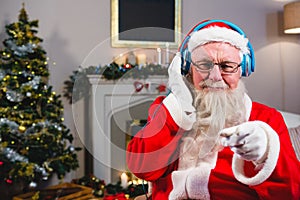 Santa Claus listening to music on headphones