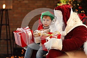 Santa Claus and little boy with Christmas gifts