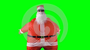 Santa Claus makes arm wave dancing moves on a green background.