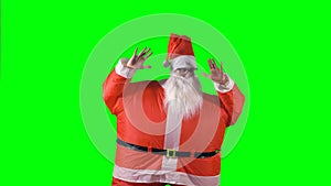 Santa Claus makes horizontal hand moves on a green background.