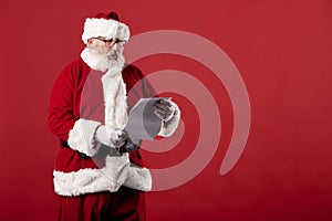 Santa Claus making gestures for a poster on a red background