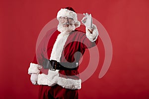 Santa Claus making gestures for a poster on a red background