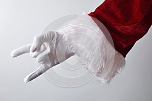 Santa Claus making horns wearing gloves and traditionally dressed