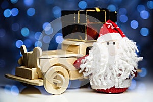 Santa Claus and old retro wooden car with gift box