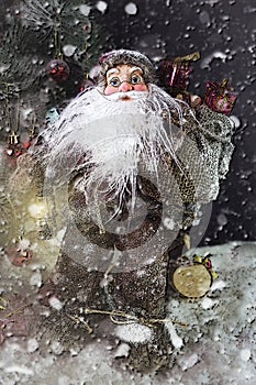 Santa Claus Outdoors Beside Christmas Tree in Snowfall Carrying Gifts to Children