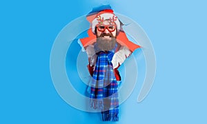 Santa Claus in party glasses looking through paper hole. Bearded man in Santa hat and blue scarf. Christmas and New year