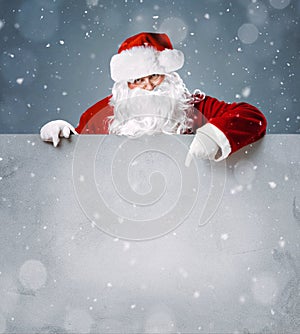 Santa Claus pointing on blank advertisement banner