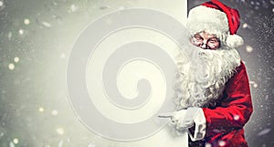 Santa Claus pointing on blank advertisement banner background with copy space photo