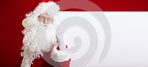 Santa Claus pointing in blank advertisement banner isolated on r