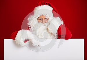 Santa Claus pointing in blank advertisement banner isolated on r