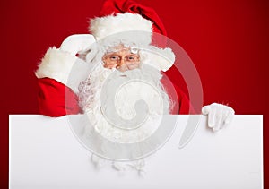 Santa Claus pointing in blank advertisement banner isolated on r