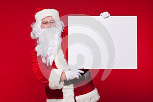 Santa Claus pointing in blank advertisement banner isolated on red background with copy space